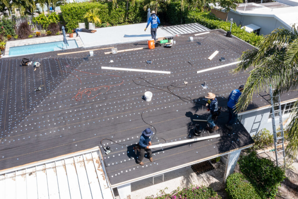 Roofers installing shingles on a Fort Lauderdale house