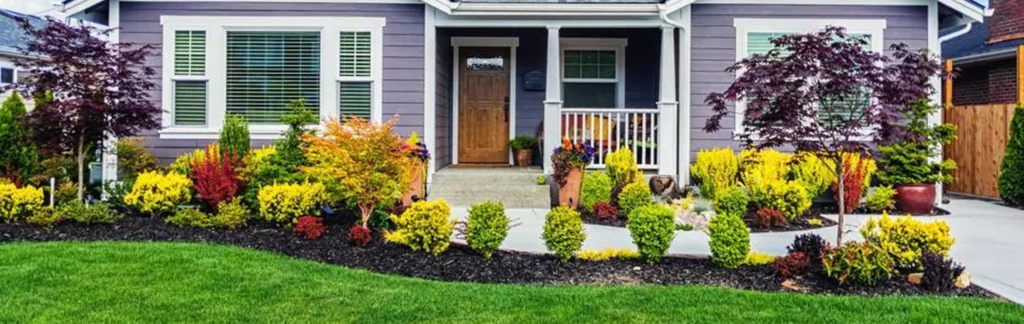 A beautifully landscaped front yard with colorful flowers, shrubs, and a manicured lawn.