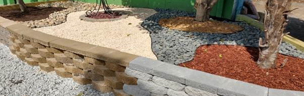 A professional landscaper installing beautiful rock features in a landscaped yard.